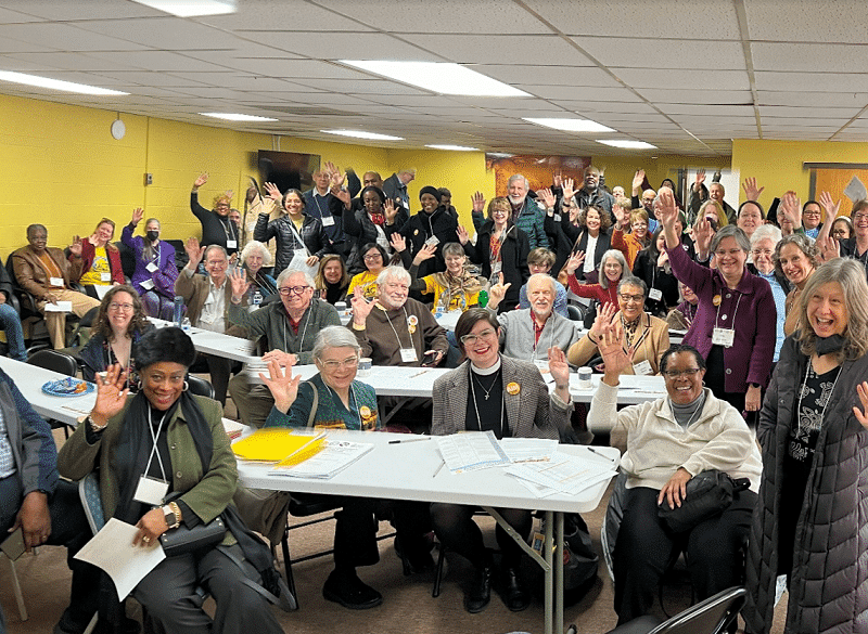 Group of 100 people smiling and waving