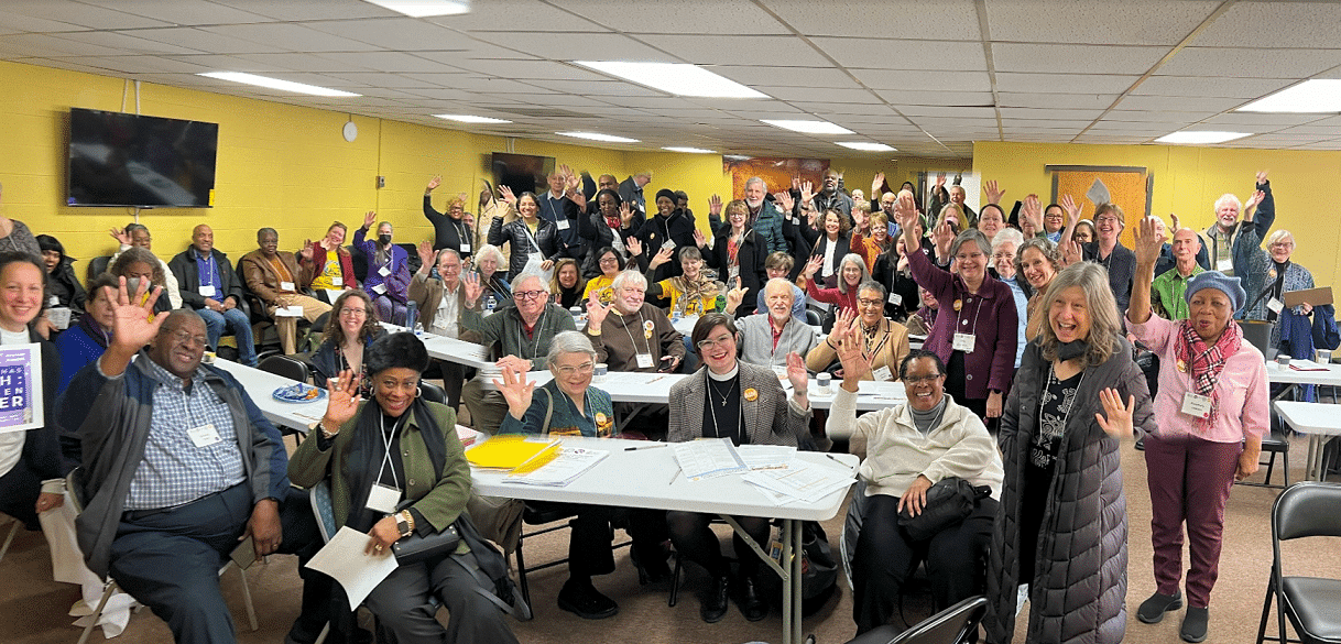 Group of 100 people smiling and waving